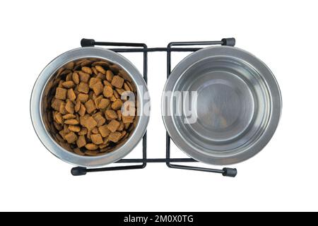 Trockenes Futter und Wasser für Katzen oder Hunde in Metallschüsseln, isoliert auf weißem Hintergrund. Draufsicht. Stockfoto