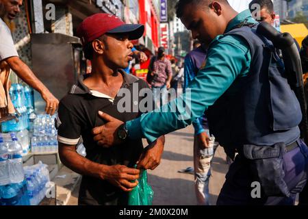 Dhaka, Dhaka, Bangladesch. 8.. Dezember 2022. Am 8. Dezember 2022 überprüfte die Polizei einen Fußgänger vor dem Zentralbüro der Bangladesch Nationalist Party (BNP) in Dhaka, im Vorfeld einer BNP-Kundgebung, die am 10. Dezember den Rücktritt von Premierminister Scheich Hasina forderte. - Mindestens eine Person starb am 7. Dezember und unzählige wurden in der Hauptstadt von Bangladesch, Dhaka, verletzt, als die Polizei Gummigeschosse und Tränengas auf Anhänger der Opposition abgefeuert hatte, bevor Hunderte von Zeugen und die Polizei verhafteten. (Kreditbild: © Abu Sufian Jewel/ZUMA Press Wire) Stockfoto