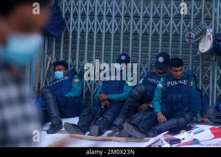 Dhaka, Dhaka, Bangladesch. 8.. Dezember 2022. Mitglieder der bangladesch-Polizei ruhen sich am 8. Dezember 2022 vor dem BNP-Zentralbüro in Dhaka auf der Straße aus, im Vorfeld einer BNP-Kundgebung, die für Dezember 10 aufgerufen wurde, um Premierminister Scheich Hasina zum Rücktritt zu zwingen. - Mindestens eine Person starb am 7. Dezember und unzählige wurden in der Hauptstadt von Bangladesch, Dhaka, verletzt, als die Polizei Gummigeschosse und Tränengas auf Anhänger der Opposition abgefeuert hatte, bevor Hunderte von Zeugen und die Polizei verhafteten. (Kreditbild: © Abu Sufian Jewel/ZUMA Press Wire) Stockfoto