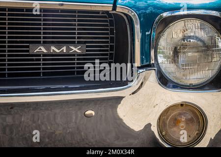 Des Moines, IA - 03. Juli 2022: Detailansicht eines 1968 AMC AMX Hardtop Coupé-Scheinwerfers und Kühlergrills auf einer lokalen Automesse. Stockfoto