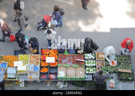 Bauernmarkt in Italien. Die Leute kaufen in den Obst- und vegetarischen Verkaufsständen des lokalen Marktes ein. Von oben gesehen, Siena, Italien Stockfoto