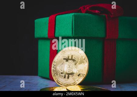 Bitcoin-Münze in rot-grüner Geschenkbox. Weihnachtsgeschenk. Stockfoto