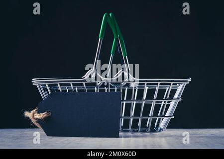 Warenkorb und leeres Preisschild für die Beschriftung. Der Preis des Produkts. Verkauf im Supermarkt. Stockfoto