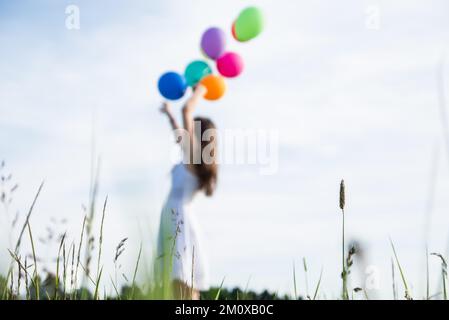 Kleines Mädchen mit Ballons. Sommerferien, Feiern, Kinder glückliches kleines Mädchen mit bunten Ballons. Porträt eines glücklichen Teenagers oder Jugendlichen. C Stockfoto