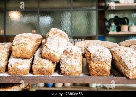 Brotlaibe auf den Regalen der Bäckerei. Frisches, hausgemachtes Weizen, Vollkornbrot und Gebäck. Hochwertiges Foto Stockfoto