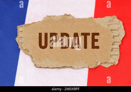 Geschäfts- und Finanzkonzept. Vor dem Hintergrund der französischen Flagge liegt Pappe mit der Inschrift - Update Stockfoto