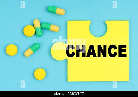 Medizin und Gesundheitskonzept. Auf blauem Hintergrund gibt es Pillen und ein Puzzle mit der Inschrift - ZUFALL Stockfoto