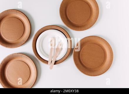 Eco Craft Einweg-Geschirr aus Holz und Recyclingpapier. Teller und Leute. Null-Verschwendung-Konzept. Weißer Hintergrund. Draufsicht Stockfoto