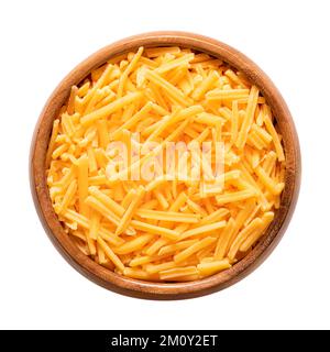 Zerkleinerter Cheddar-Käse in einer Holzschüssel. Geriebener Naturkäse, pikant, orange gefärbt mit Annatto, eine natürliche Lebensmittelfarbe. Stockfoto