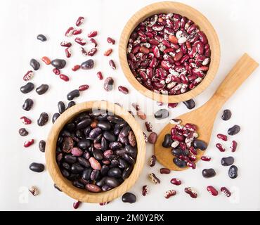 Rote und schwarze Kidney Beans. Holzplatten und Löffel. Draufsicht Stockfoto