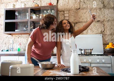Eine multirassische Familie macht ein Selfie in der Küche ihres Hauses Stockfoto