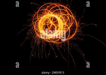 Kreise mit Funken auf schwarzem Hintergrund. Festliche Glitzer, abstrakte Silvesterlichter. Stockfoto