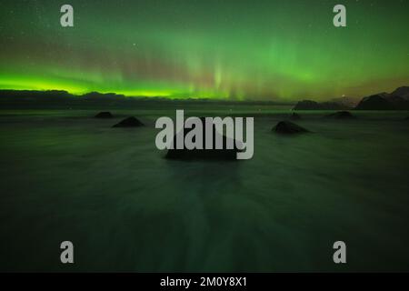 Nordlichter am Himmel über felsigem Strand, Lofoten-Inseln, Norwegen Stockfoto