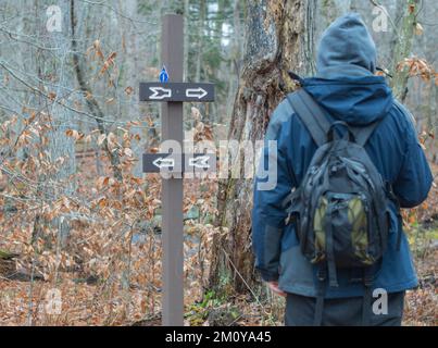 Überqueren Sie die Straßen auf dem Wanderweg, unterschreiben Sie die Entscheidung in welche Richtung Stockfoto