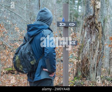 Überqueren Sie die Straßen auf dem Wanderweg, unterschreiben Sie die Entscheidung in welche Richtung Stockfoto