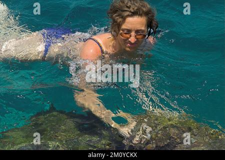 Hydra, Idra, Ύδρα, Grecja, Griechenland, Griechenland; Eine Frau mit Brille badet im Meer; eine Frau mit Brille badet im Meer; Kobieta kąpie się w morzu Stockfoto