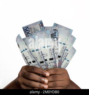 Schwarze Hände mit 3D gerenderten saudischen riyal Notes. Nahaufnahme von Händen, die Saudi-arabische Währungsscheine halten Stockfoto