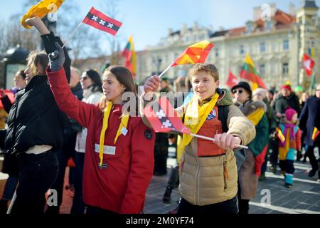 VILNIUS, LITAUEN - 11. MÄRZ 2022: Fröhliche Menschen mit dreifarbigen litauischen Flaggen auf festlichen Veranstaltungen, als Litauen den 32.. Jahrestag beging o Stockfoto