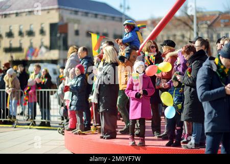 VILNIUS, LITAUEN - 11. MÄRZ 2022: Fröhliche Menschen mit dreifarbigen litauischen Flaggen auf festlichen Veranstaltungen, als Litauen den 32.. Jahrestag beging o Stockfoto