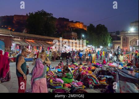 Jodhpur, Rajasthan, Indien - 19.10.2019 : Ausländer kaufen Rajasthani Frauen Kleidung, die auf berühmten Sardar Markt und Ghanta ghar Uhr Turm in verkauft Stockfoto