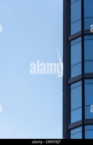 Blick von unten auf moderne Wolkenkratzer im Geschäftsviertel vor blauem Himmelsflugzeug-Hintergrund Stockfoto