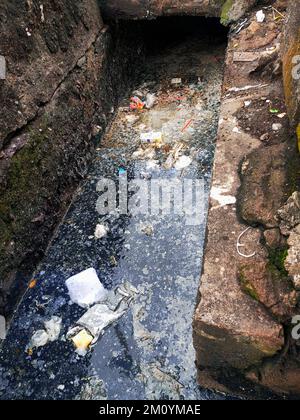 Jakarta, Indonesien - 5. Dezember 2022: Abflüsse voller Müll. Städtische Umweltverschmutzung. Abfallbehandlung. Stockfoto