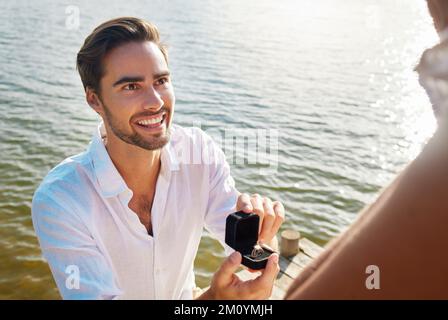 Sag Ja, damit ich für immer glücklich werde. Ein junger Mann, der seiner Freundin einen Heiratsantrag macht. Stockfoto