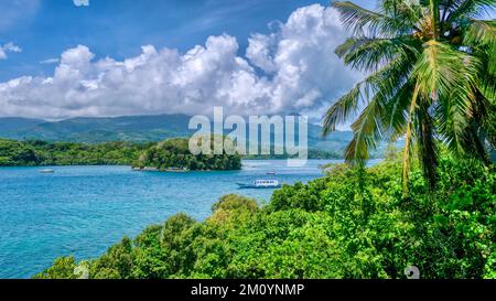 Weitwinkelblick auf die Dalaruan Bay und die wunderschönen Berge und die Küste des beliebten Badeorts Puerto Galera auf Mindoro Island, Philippinen Stockfoto