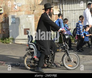 Ein jüdischer Haredi-Mann, der mit dem Fahrrad im Mea Shearim-Viertel in Jereusalem, Israel, fährt. Stockfoto