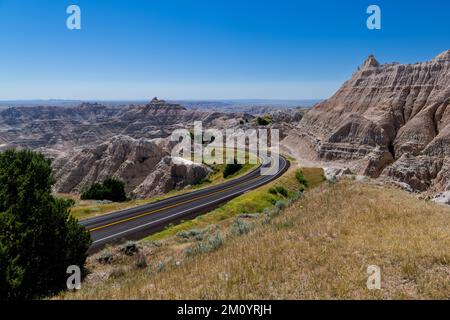 Der Highway schlängelt sich durch die farbenfrohe Landschaft der Gipfel des Badlands-Nationalparks in South Dakota Stockfoto