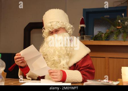 Himmelsberg, Deutschland. 07.. Dezember 2022. Manuela Verges als der Weihnachtsmann von der Santa Claus Post Office Association Briefe im Haus des Weihnachtsmanns bei der Weihnachtspost in Himmelsberg, einem Bezirk von Sondershausen, liest. Kredit: Bodo Schackow/dpa/Alamy Live News Stockfoto