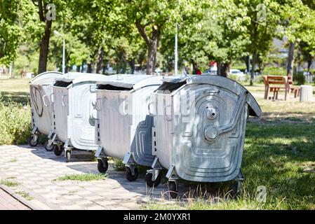 Mülltonnen im Stadtpark. Müllcontainer in einem öffentlichen Park. Umwelt, Stadtleben, sanitäre Standards Stockfoto