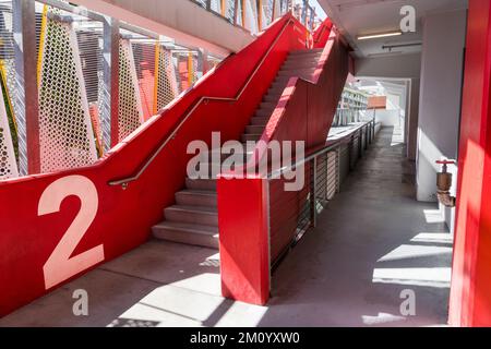 Moderne Struktur einer Parkgarage mit Betontreppe mit roten Wänden und der Nummer 2 Stockfoto