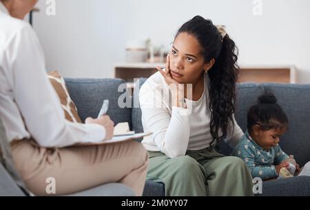 Das ist kein Hört sich gut an. Eine attraktive junge Frau, die mit ihrer Tochter während einer Beratung mit einem Psychologen sitzt. Stockfoto