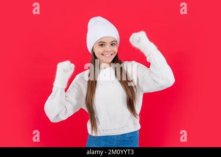 Fröhliches Teenager-Mädchen in warmer Winterstrickmode Pullover und Fäustlinge im Studio. Ein junges Wintermädchen Stockfoto