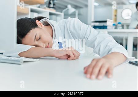 Planänderung - ich gebe auf. Ein junger Wissenschaftler, der an einem Schreibtisch in einem Labor schläft. Stockfoto