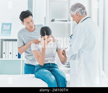In völligem Unglauben darüber. Ein junges Paar, das schlechte Nachrichten von seinem Arzt bekommt. Stockfoto