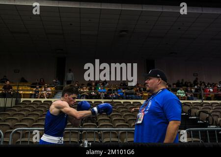 Lubbock, TX, USA. 8.. Dezember 2022. Kooper Pardee aus Cleveland, TN, erwärmt sich vor seinem Kampf auf dem Deck, während sein Coach den Blick überblickt. (Kreditbild: © Adam DelGiudice/ZUMA Press Wire) Stockfoto