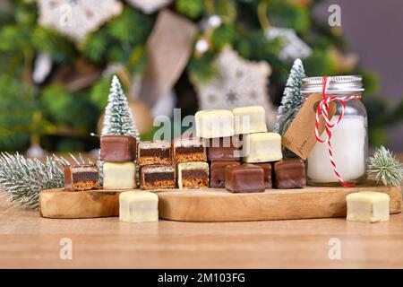 Traditionelle deutsche Süßigkeiten namens Dominosteine. Weihnachtsbonbons, bestehend aus Lebkuchen, Gelee und Marzipanschichten mit braunem und weißem Cho Stockfoto