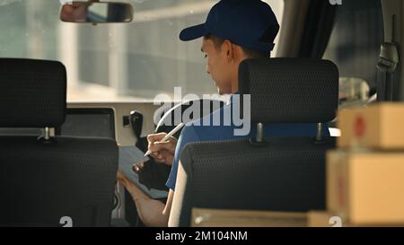 Rückansicht des Kurierdienstes mit einem Tablet-PC im Lieferwagen. Lieferservice, Transport und Versandkonzept Stockfoto