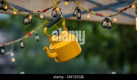 Gelbe Teekanne. Weicher Fokus auf natürlich verschwommenem Hintergrund Stockfoto