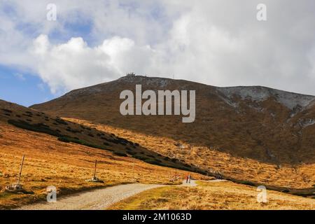 Langer Feldweg durch eine hügelige Landschaft mit Blick auf den Gipfel vom höchsten Berg in niederösterreich Stockfoto