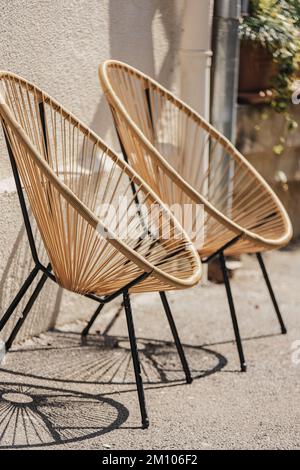 Cafe-Möbel. Trendige Designer-Stühle. Rattan-Korbsessel. Korbsessel Stehen Draußen. Moderne Möbel An Der Straße. Designer-Sessel Stockfoto