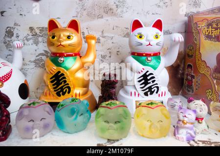 Nahaufnahme von Maneki Neko (japanische Weckkatzen) in einem Restaurantfenster in China Town, Soho, London, England, Großbritannien Stockfoto