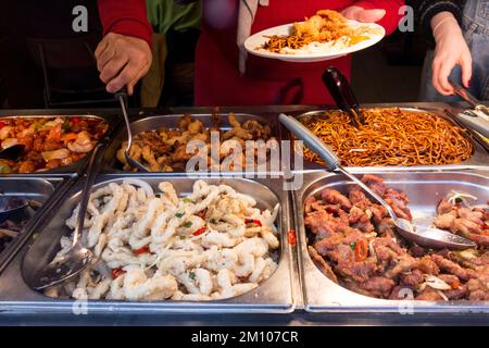 Kunden, die sich selbst an einem Selbstbedienungsbuffet bedienen, China Town, Soho, London, England, UK. Stockfoto