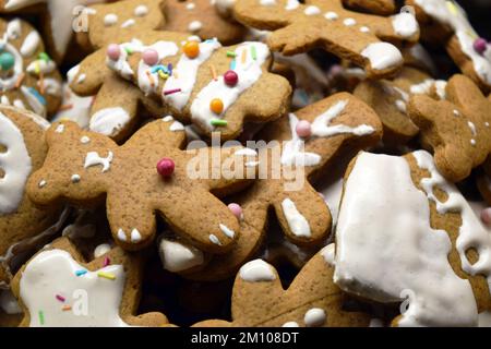 Süßes Lebkuchen hausgemachte Figuren zu Weihnachten, dekoriert mit weißem Glasur und farbigen Süßigkeiten: teddybären, Lebkuchen-Mann, Weihnachtsbaum, Sterne. Stockfoto