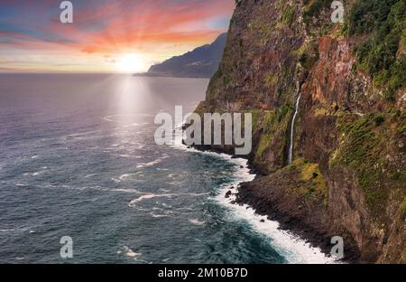 Madeira Island - dramatischer Sonnenaufgang über dem atlantischen Ozean mit Wasserfalllandschaft von Miradouro do VEU da Noiva Stockfoto