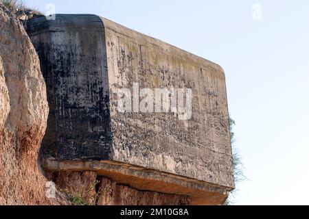 Die Rückwand eines alten Kasematats aus dem Zweiten Weltkrieg blieb am Ufer des Schwarzen Meeres hängen, das der Erosion ausgesetzt war. Stockfoto