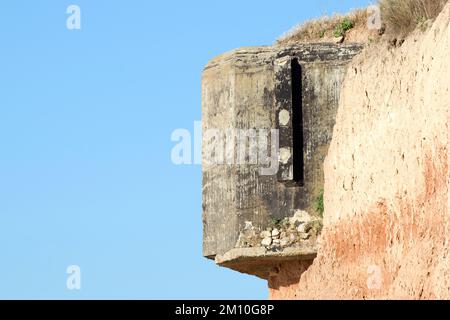 Die Rückwand eines alten Kasematats aus dem Zweiten Weltkrieg blieb am Ufer des Schwarzen Meeres hängen, das der Erosion ausgesetzt war. Stockfoto