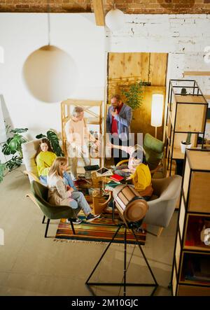 Draufsicht auf Mitarbeiter, Männer und Frauen, Besprechungen, Gespräche im Büro, drinnen. Fotoindustrie. Geschäftskonzept, Brainstorming Stockfoto